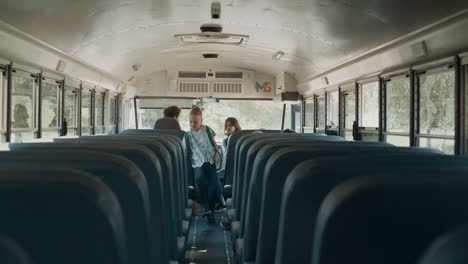 multiethnic school children boarding on schoolbus. joyful children taking seats.