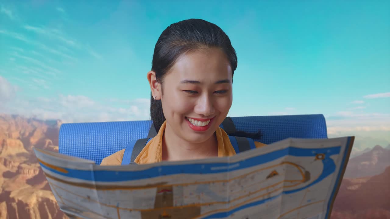 Close Up Of Asian Female Hiker With Mountaineering Backpack Looking At The Map Then Looking Around While Traveling At The Top Of Mountain