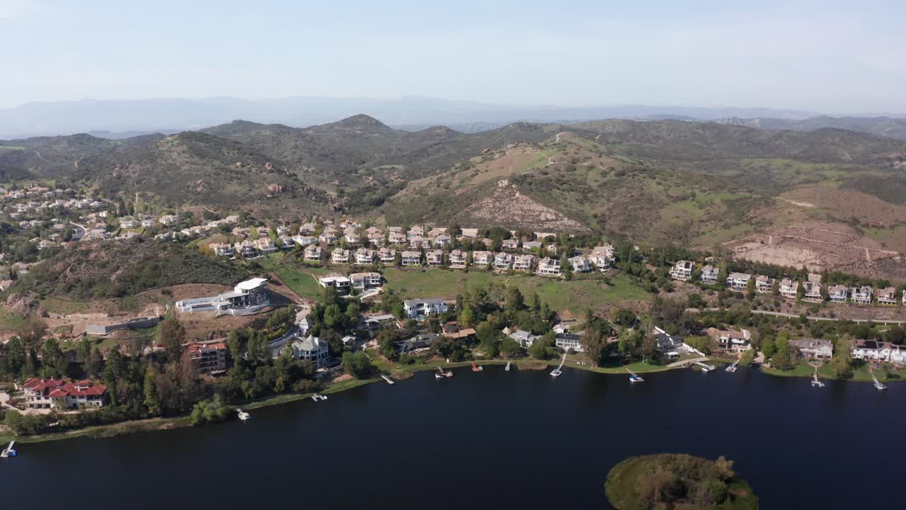 Aerial high panning shot of a luxurious residential neighborhood along Lake Sherwood in Southern California. 4K at 30 FPS