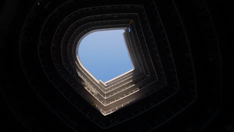 silhouette of a man who shoots video on a phone or smartphone. tourist takes a series of photos on the background of a modern round building with a blue sky on top. contemporary architecture. selfies