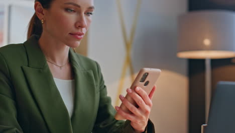 thoughtful woman watching mobile phone in office closeup. lady enjoying webinar
