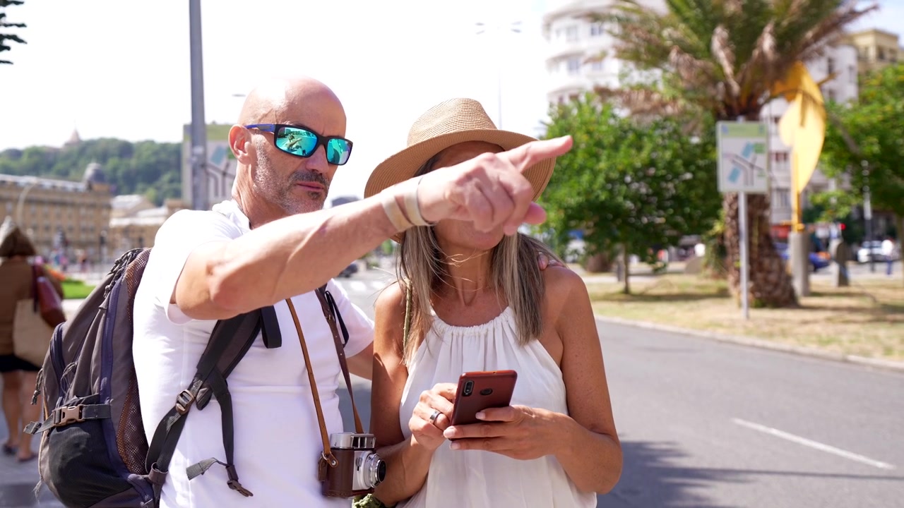 Pareja madura usando un smartphone para navegar mientras viajan