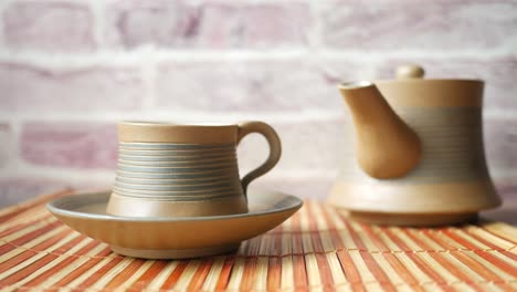 ceramic tea cup and pot on bamboo placemat