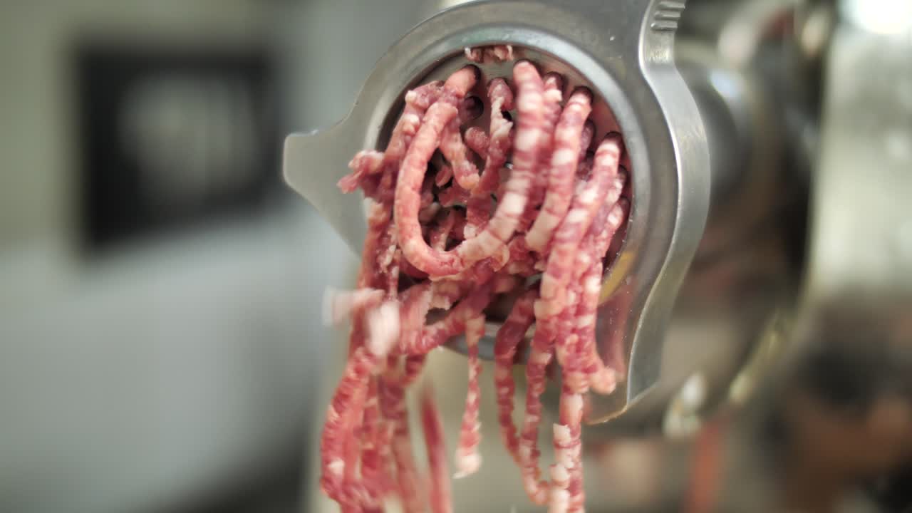 Grinder machine producing minced meat, close up