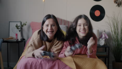 sisters playing video games in bedroom