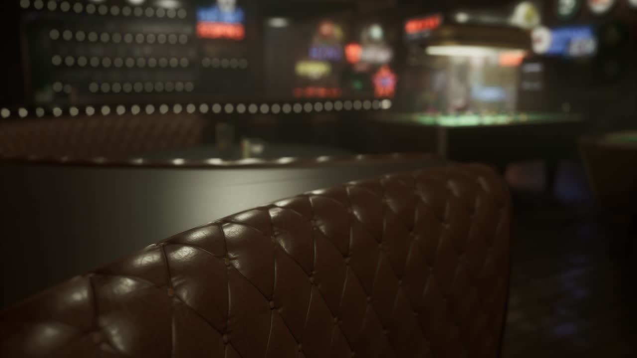 Dimly lit lounge with leather seating and sports screens in the background