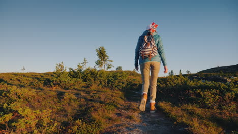 A-Tourist-With-A-Norwegian-Flag-In-A-Backpack-Walks-Through-The-Picturesque-Highlands-At-Dawn-Active