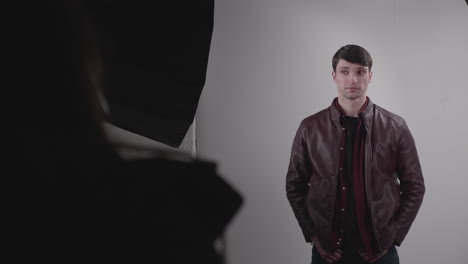 good-looking man wearing leather jacket modelling in photo studio on white background