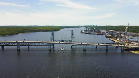 drone footage showing sagadahoc bridge, and cars driving on the rte1 in the city on bath, maine