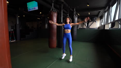 mujer haciendo ejercicio en un gimnasio con saltos y bolsas de boxeo