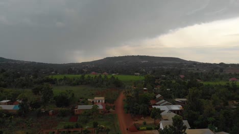 Aerial-shot-of-a-rural-African-village-with-rainy-storm-clouds-over-a-mountain-in-the-monsoon-season