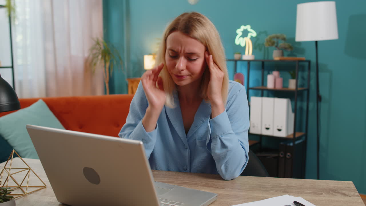 Tired ill businesswoman suffering from headache problem tension migraine stress at home office desk