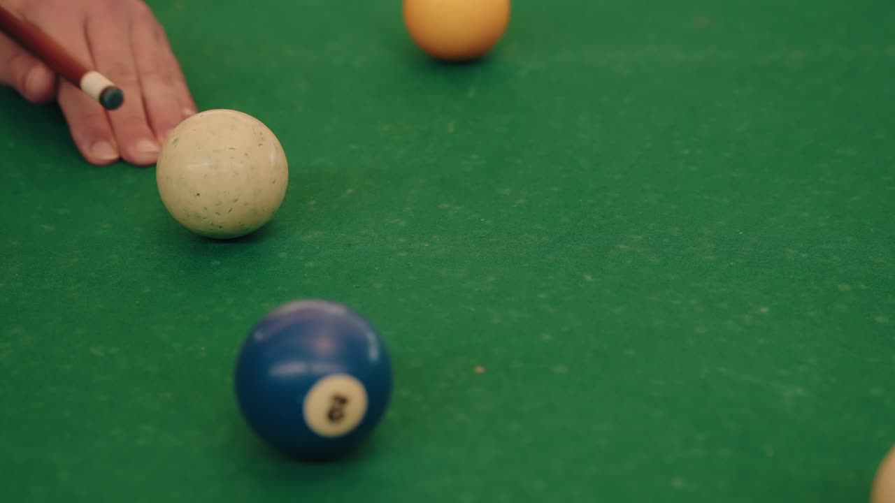 Player aims cue ball with stick on green billiard table close up moment focus on action