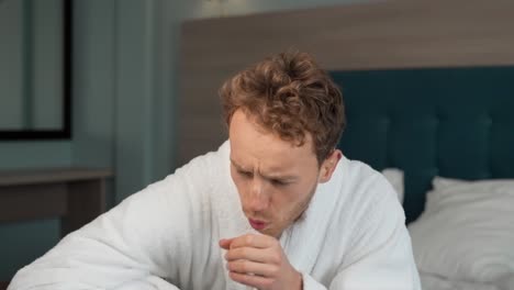 an adult man coughs and measures the temperature with a non-contact thermometer