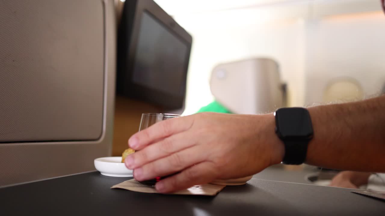 Person eating snacks and drinking on an airplane