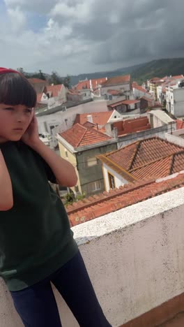 young girl listening to music on a rooftop