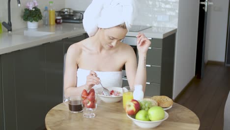 bella mujer de mediana edad sentada en su cocina por la mañana