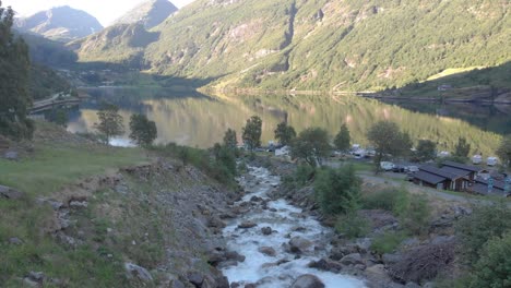 The-drone-is-following-waterfall-which-becomes-a-river-and-flows-into-the-Geiranger-fjord