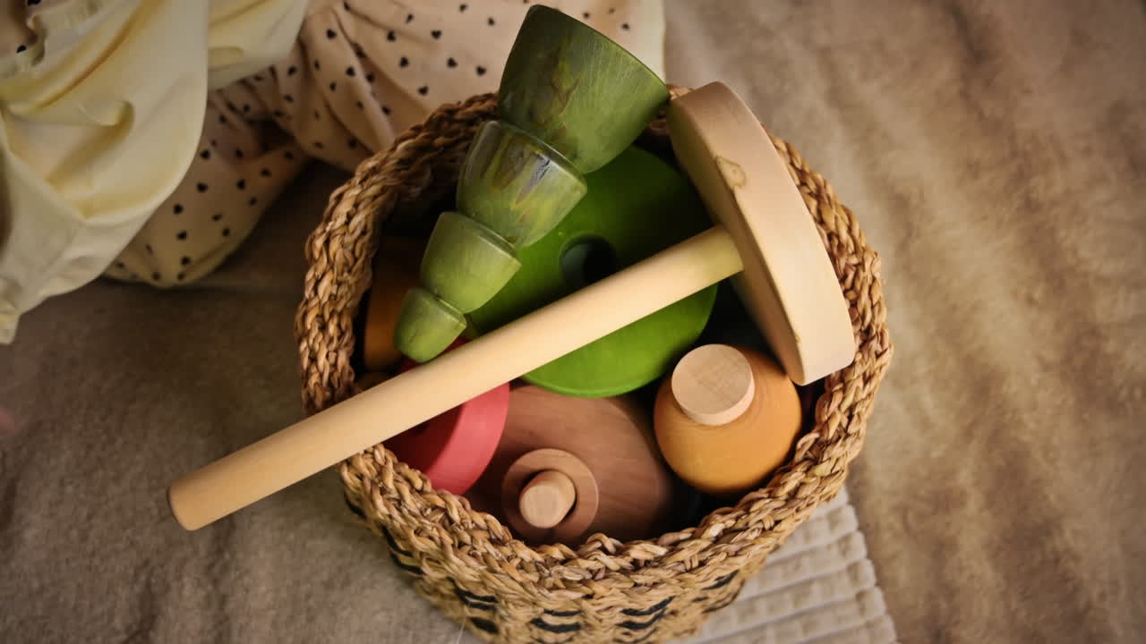 Overhead view of the little girl's hands put wooden toys in the basket. Ecological and sustainability concept
