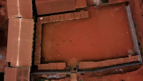 birds eye drone shot above an urban street soccer game in the suburbs of yaounde, cameroon