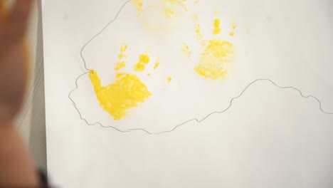 child making hand prints on paper. early childhood education. little painter.
