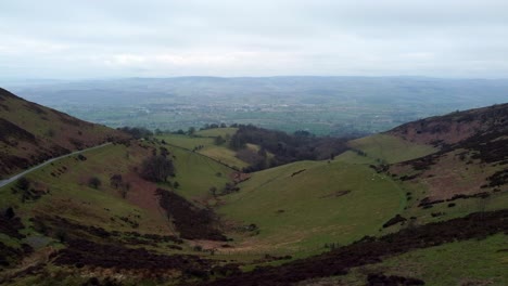 Narrow-single-rural-road-running-through-Welsh-rolling-mountain-valleys-landscape-aerial-dolly-right