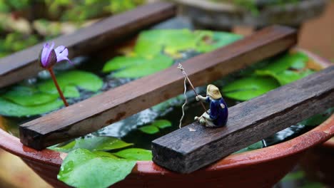 slowed static shot of lotus plants and decorations with rain