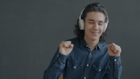 young man dancing to music with headphones