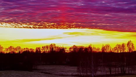 static shot of purple clouds passing by over beautiful yellow sky during sunset over the horizon in timelapse