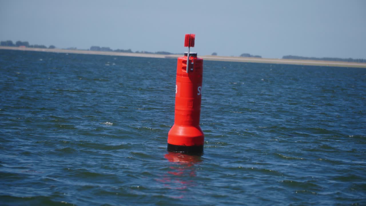 una boya roja en medio del mar en cámara lenta