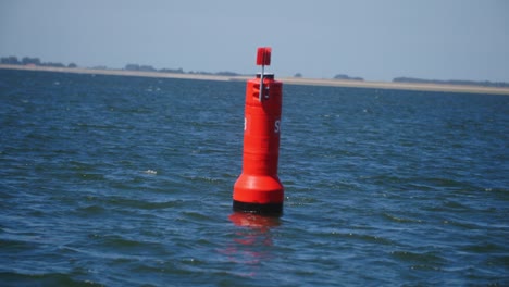 una boya roja en medio del mar en cámara lenta