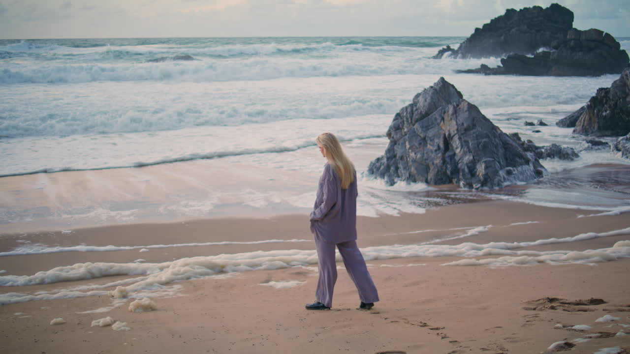 спокойная женщина размышляет о волнах, ступая по пляжу, одинокий путешественник на берегу, закат.