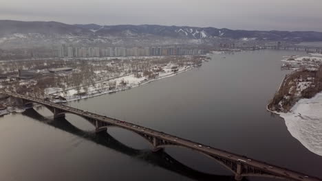 aerial view of a city bridge over a river in winter