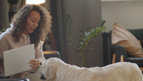 mujer relajándose en casa con una computadora portátil y un perro