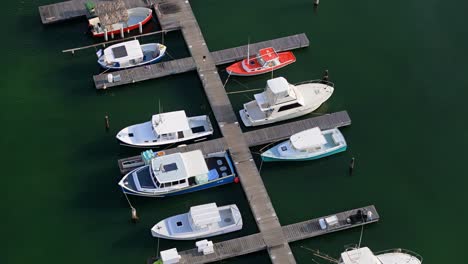 drone orbit around wooden docks of spanish waters curacao as anchored boats bob in water