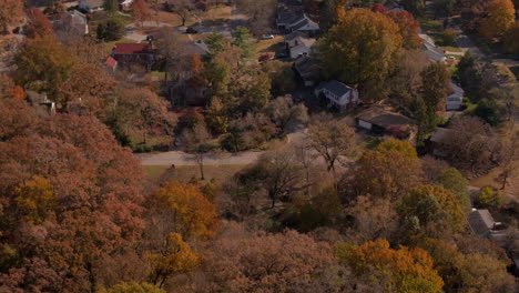 inclínate hacia arriba para revelar un agradable vecindario suburbano entre árboles de otoño