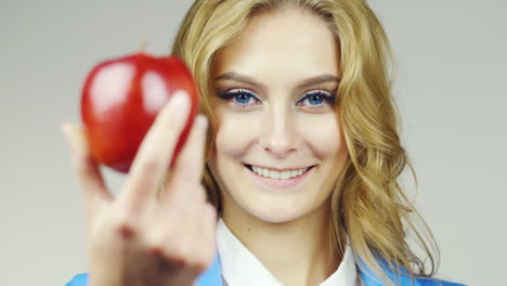 Portrait-Of-Attractive-Blue-Eyed-Woman-Holds-Up-A-Red-Apple-Hd-Video