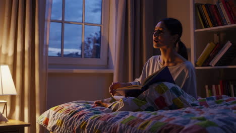 mujer leyendo en la cama por la noche
