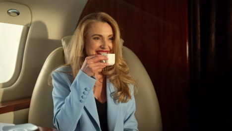 hermosa mujer de negocios volando en un avión disfrutando de un café en un primer plano de luz solar dorada.