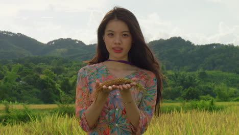 Retrato-De-Una-Joven-Agricultora-Vietnamita-Que-Muestra-Un-Cultivo-De-Arroz-En-El-Campo-Agrícola-Sonriendo-A-La-Cámara-Vistiendo-Ropa-Tradicional