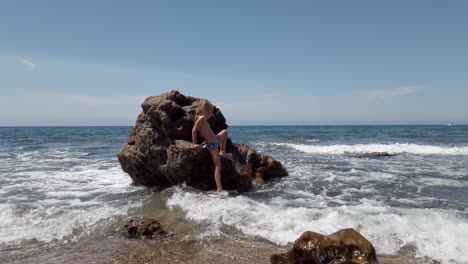 Kaukasisches-Mädchen-Auf-Dem-Großen-Felsen-Mit-Meereswellen-Am-Strand-Von-Cabo-De-Gata-In-Spanien