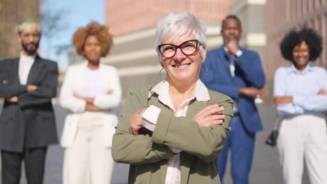 smiling mature businesswoman standing in front of a business team