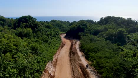 Capa-De-Grava-Construida-De-Carretera-Que-Serpentea-A-Través-De-La-Jungla-De-Indonesia,-Vista-Aérea