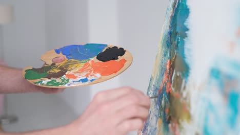 a closeup of an artist using a brush to create a modern masterpiece of oil painting - a close-up of an artist using a brush to create a modern masterpiece of oil painting. the process of creating an abstract painting. video