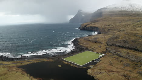 islas feroe, 4k aérea de niðara vatn campo de fútbol con hermosas montañas en el fondo