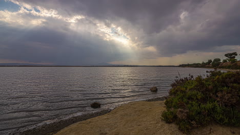 timelapse con una hermosa vista del atardecer de un lago de montaña y un cielo despejado con las llamaradas del sol poniente