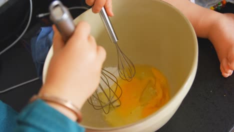 siblings stirring eggs with whisker 4k