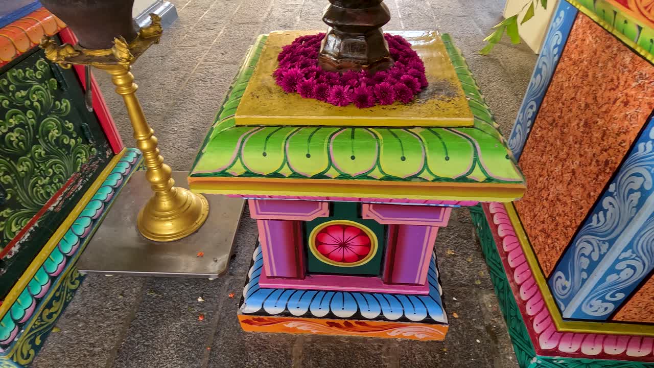 Colorful Hindu temple altar with flower garlands, vibrant decor, and steady forward camera movement