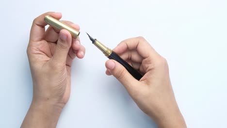 hands holding a fountain pen