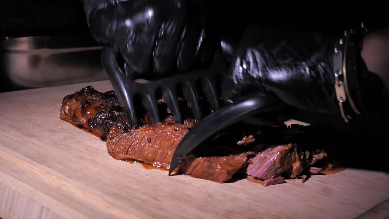 알아볼 수 없는 요리사가 목판에 쇠고기를 뽑고 준비하고 있습니다.